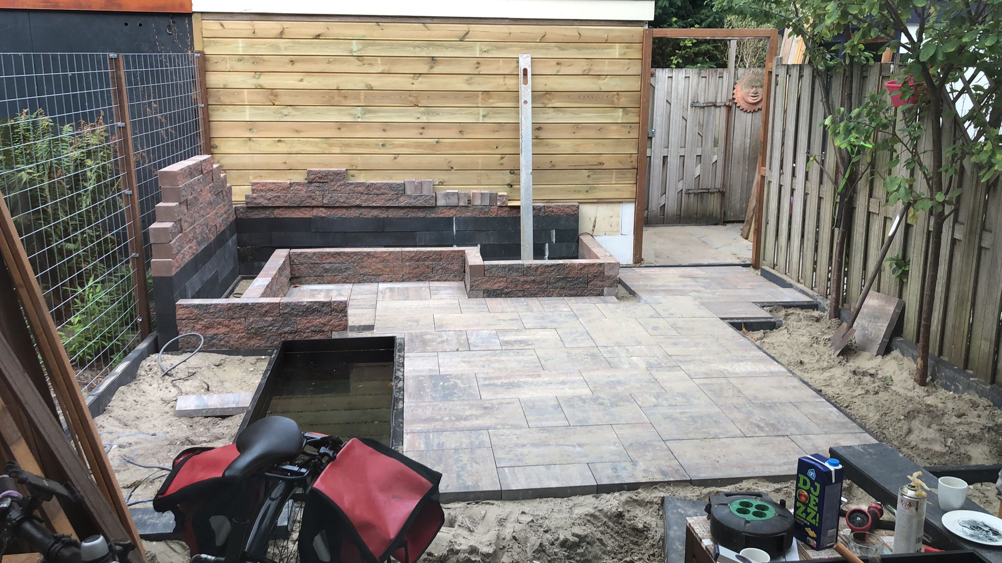 Empty backyard with dry lawn and minimal landscaping before garden design