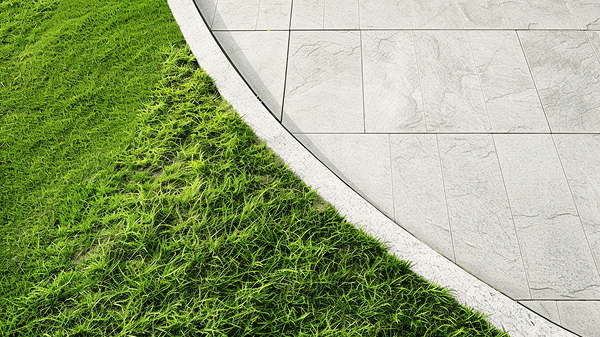 Curved stone patio with grass, outdoor design detail